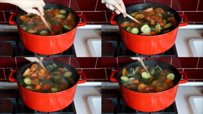 红锅用手搅拌煮沸的蔬菜汤