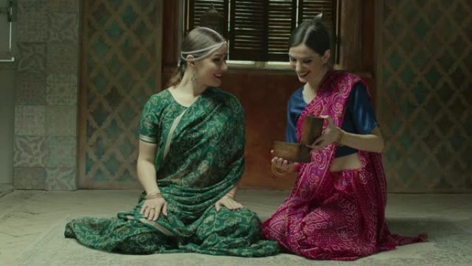 穿着印度教纱丽的女人看着珠宝盒