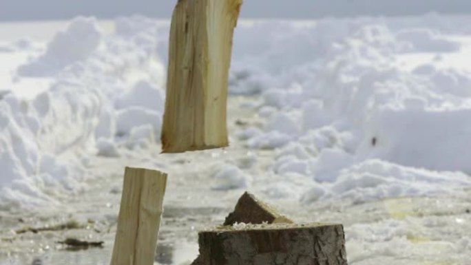 男子在雪地里砍柴冬季村庄慢动作