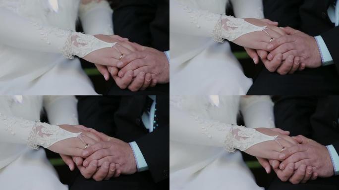 新婚夫妇牵手。婚礼鲜花。特写