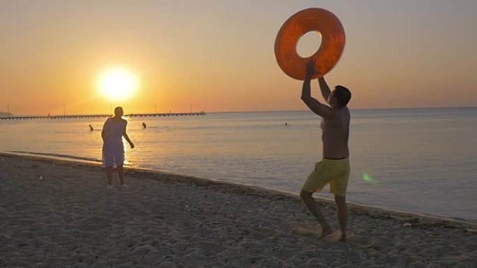 年轻夫妇在海边玩橡胶圈
