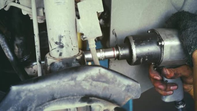 在汽车修理厂工作的男机械师。