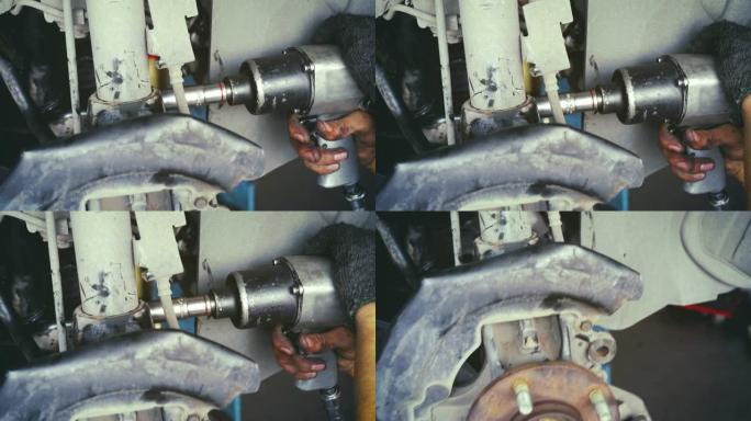 在汽车修理厂工作的男机械师。