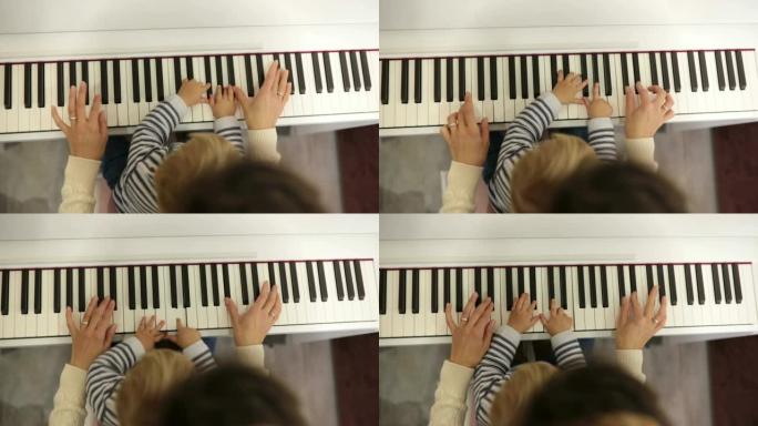 甜蜜积极的蹒跚学步的孩子和妈妈在弹钢琴。幼儿早期音乐教育。