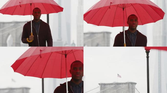 一名男子拿着雨伞向摄像机慢动作地走了布鲁克林大桥