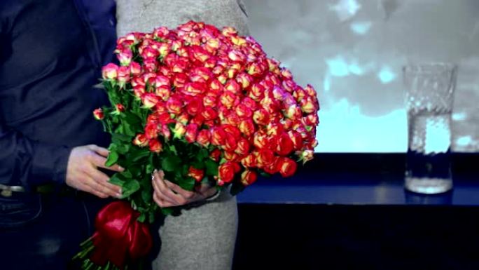 女人手里拿着一百朵粉红玫瑰。你心爱的粉红玫瑰大束礼物