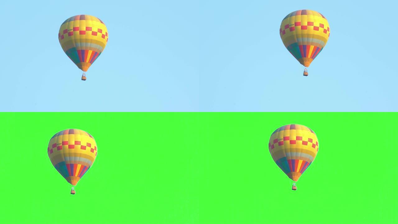 在壮观的白色天空和绿色屏幕或色度键背景下，从左向右飞行的黄色彩色单个热气球的4k视频跟踪镜头。