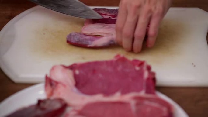 厨师切掉侧面牛肉牛排上的肉中的脂肪