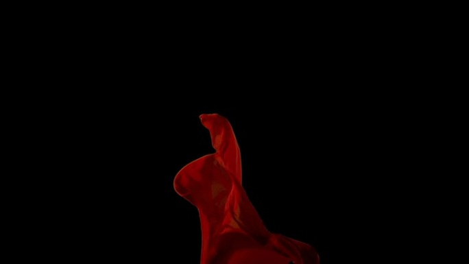 黑色背景上的红色织物在空中流动。慢动作
