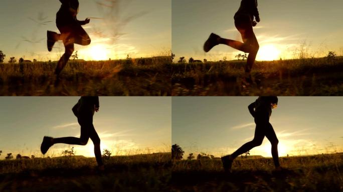 日落时跑步慢动作的女人的剪影，概念锻炼和健康，慢动作
