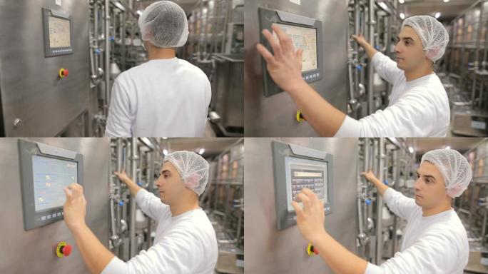 在控制站的一家食品厂工作的年轻人。手放在触摸屏上