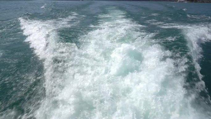 从旅客渡轮的后视图拍摄的4k视点跟踪照片，该渡轮在台湾日月潭挥舞着鲜亮的绿色水，并溅起泡沫。
