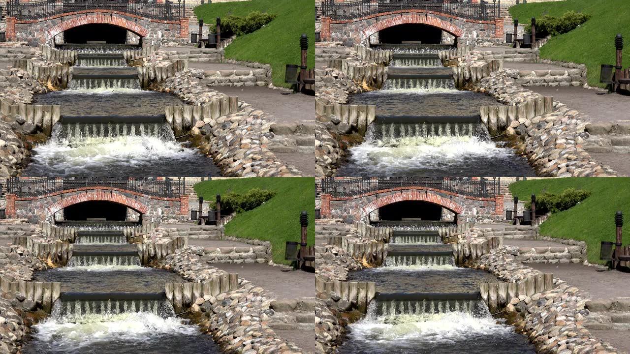 河溪瀑布水楼梯在公园路径之间流动。4K