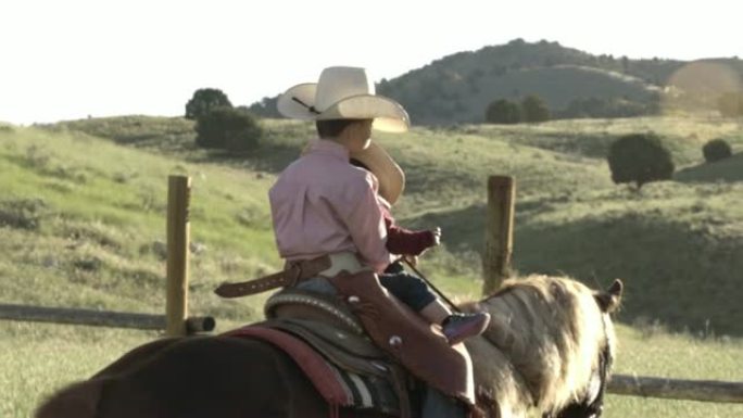 两个小男孩在田野里骑马