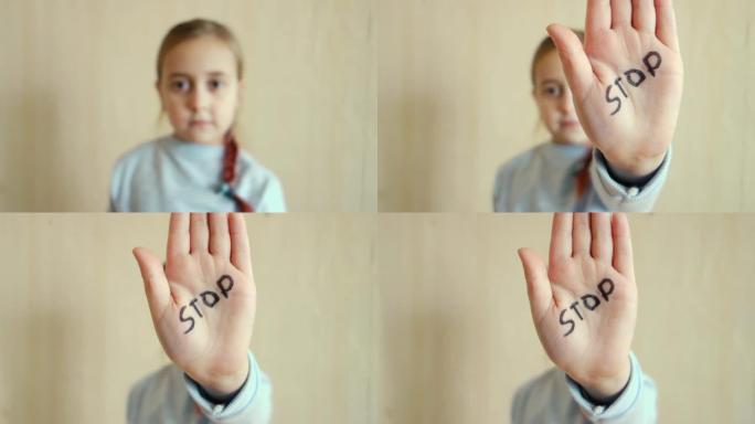 家庭暴力和虐待儿童的概念。一个小女孩展示她的手，上面写着停止这个词。儿童暴力。