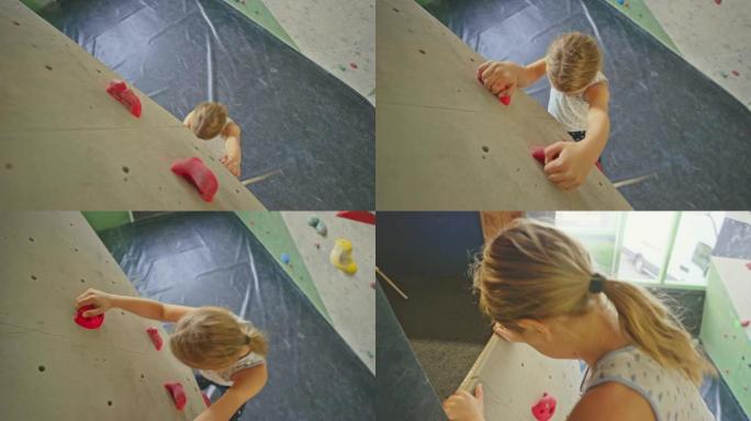 女孩在攀岩馆里爬墙