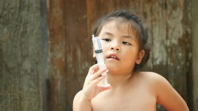 泰国儿童用注射器玩水