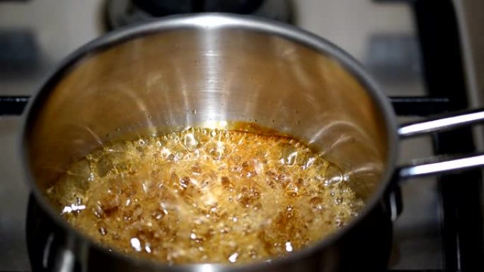 烹饪焦糖。厨师在锅里准备焦糖。煮糖。焦糖制备的技术工艺。