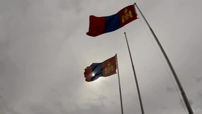 蒙古国旗在阴天的旗杆上迎风飘扬
