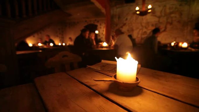 爱沙尼亚塔林老餐厅的木桌上燃烧蜡烛