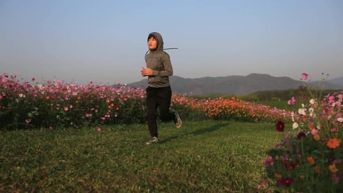亚洲女性早上在宇宙花田慢跑