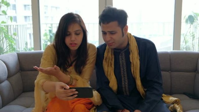 年轻的印度夫妇在得到一场悲剧的信息时心碎了，他们只能难以置信地摇头