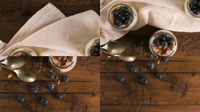 酸奶冻糕配蓝莓和格兰诺拉麦片。健康早餐概念放在梅森罐子里，木桌上有装饰勺子。