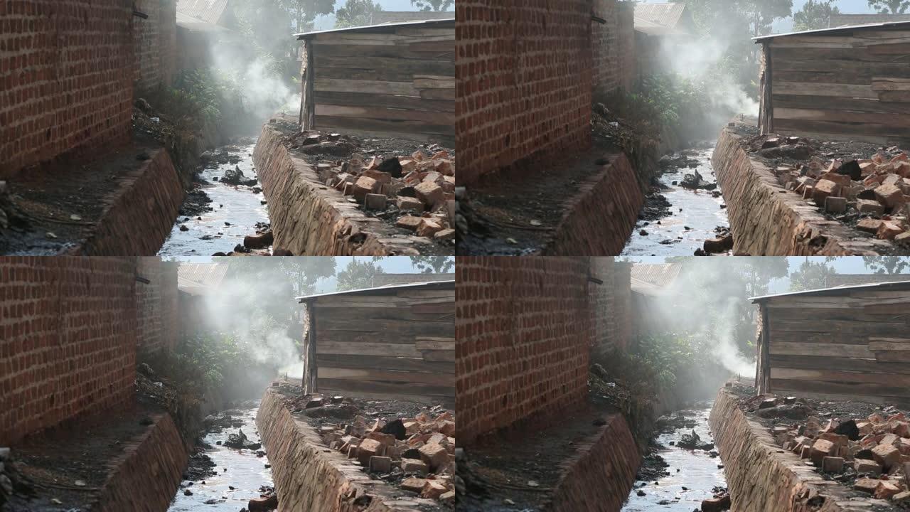 非洲小镇的污水沟，附近的烟雾从家中冒出来