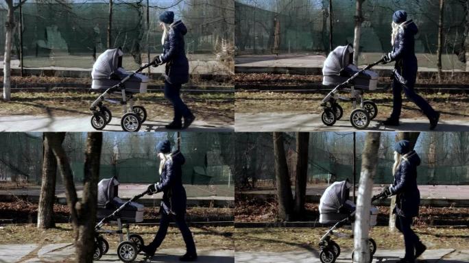 年轻的母亲带着婴儿车散步