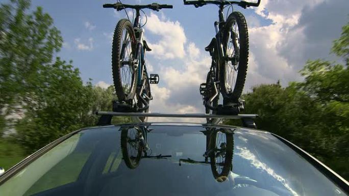 带有两辆自行车的汽车在自行车车顶托架上行驶