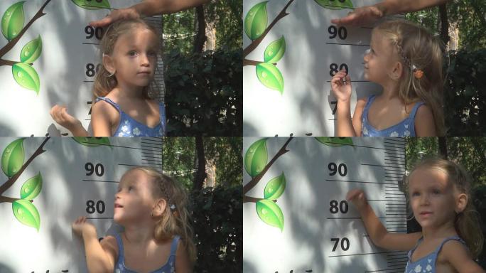 儿童通过增加身高面板来玩耍，女孩测量