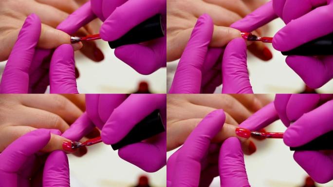 专家用红色清漆覆盖客户的指甲。特写
