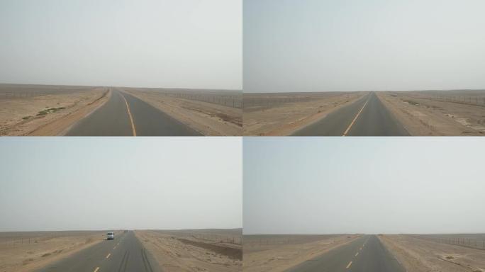 有人在空旷的沙漠道路上驾驶车辆的观点，高角度，快速模式，驾驶员视图。