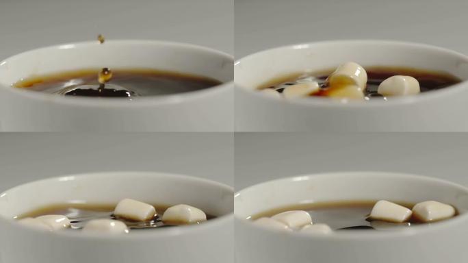 慢动作: 棉花糖的特写镜头落入一杯黑咖啡中-特写镜头