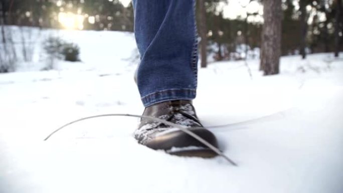 人的脚在雪地上行走的特写镜头。慢动作拍摄