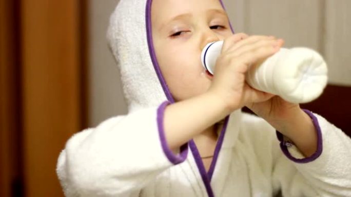 小女孩喝奶瓶、开菲尔、乳制品中的牛奶饮料。婴儿微笑着，露出酸奶中的白色胡须。