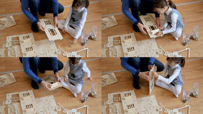 小女孩和父亲一起建造木制玩具屋