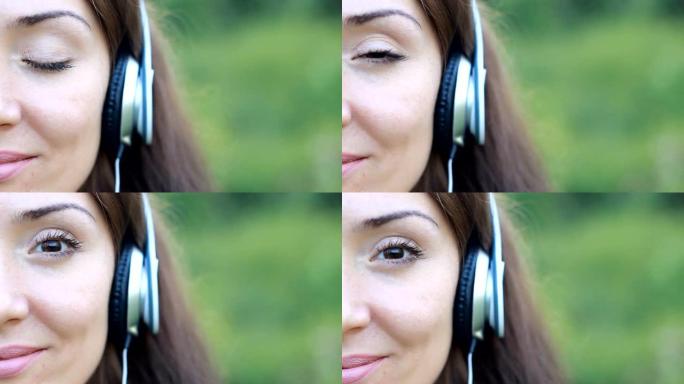 女人在户外闭着眼睛戴着耳机听音乐。一个美丽的特写女孩的肖像