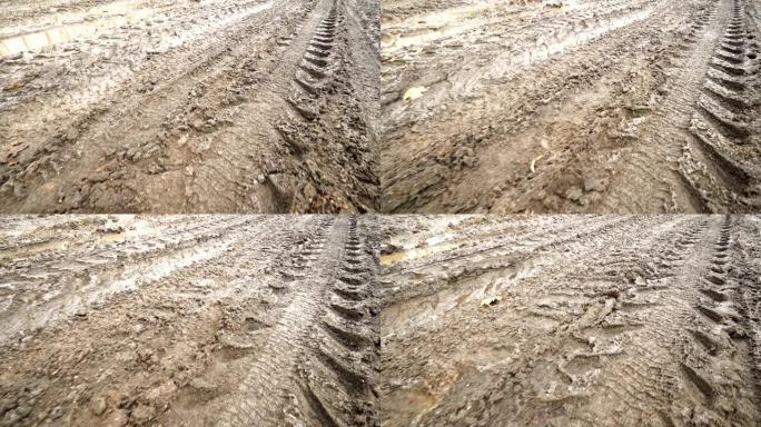 春天有泥泞水坑的乡村土路。沿轮胎轨迹运动