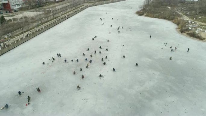 河的鸟瞰图，冰上的渔民。阴天的冬日。乌克兰能源公司。4k视频