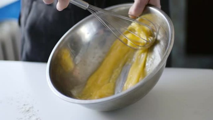 女人准备自制煎蛋卷和打蛋器混合的慢动作作物镜头。
