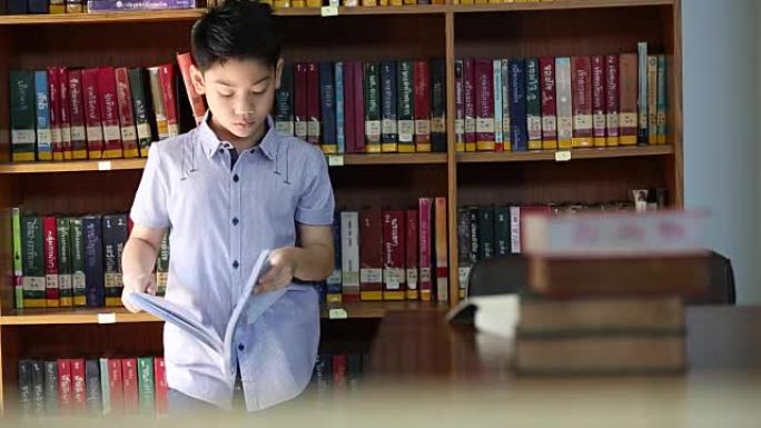 亚洲小男孩蜜蜂厌倦了阅读，泰国的图书馆