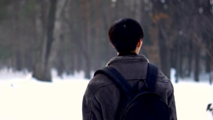 云台跟随枪击 -- 年轻的日本男子在寒冷的冬日在公园散步