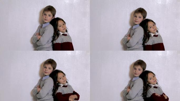 可爱的小女孩和男孩在照相馆摆姿势。