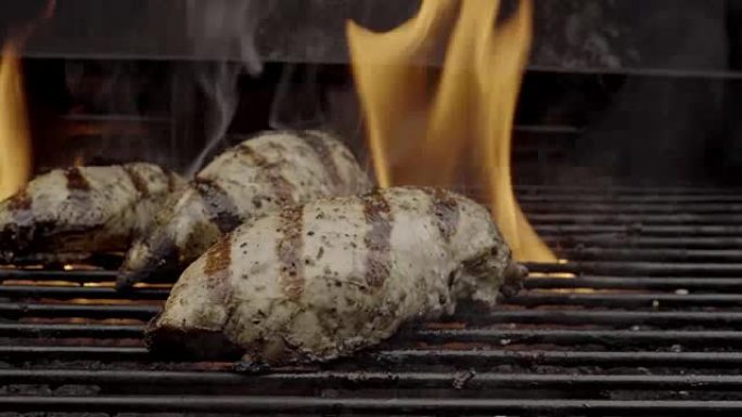 在燃烧的烤架上烧烤鸡胸肉