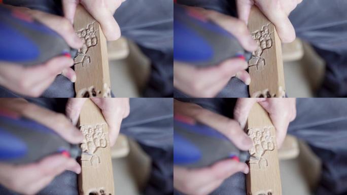 成熟工匠使用电动木雕工具在未来椅子腿上做装饰的特写