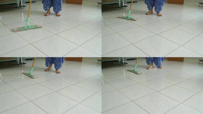女人用拖把洗地板上的污垢