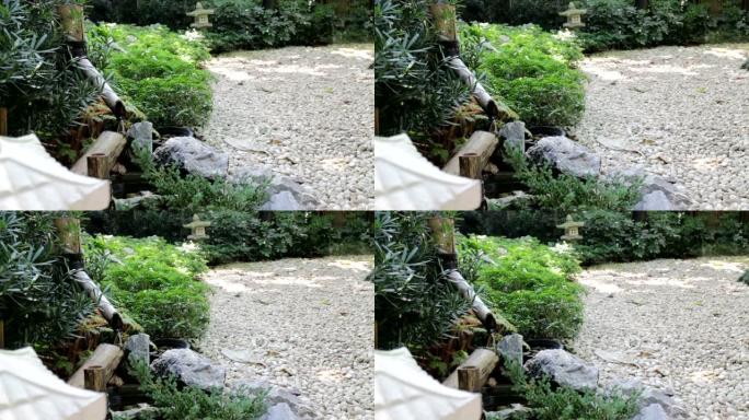 水从木制喷口流出，流入日本石园