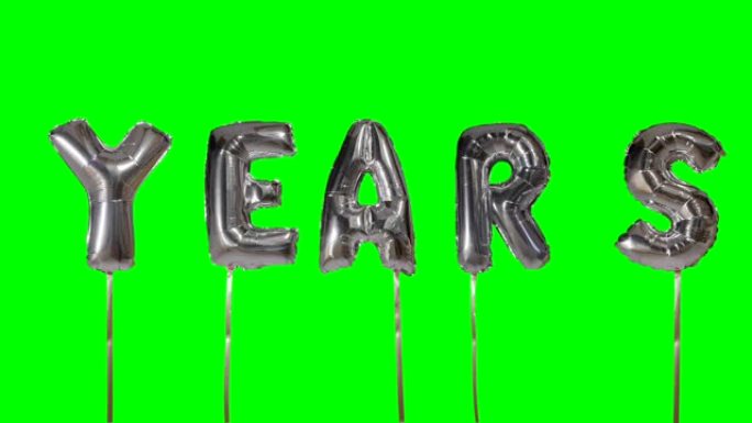 漂浮在绿色屏幕上的氦银气球字母的单词年份