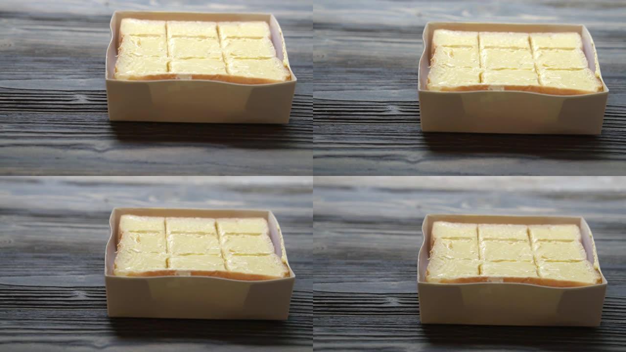 面包将黄油涂在木桌上，早餐食品与奶酪奶油美味可口，运动。